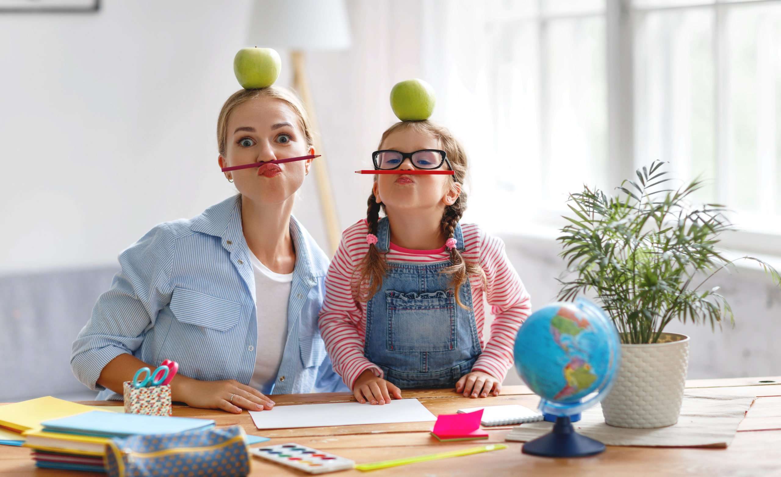 Funny mother and child daughter making homework creative